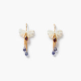 A pair of gold-tone dangle earrings featuring a small white shell bow, a lens-shaped garnet gemstone, and two dangling blue teardrop beads, set against a plain white background.