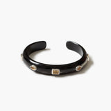 A glossy black  horn open cuff bracelet with three small geometric inset stones in silver-toned settings